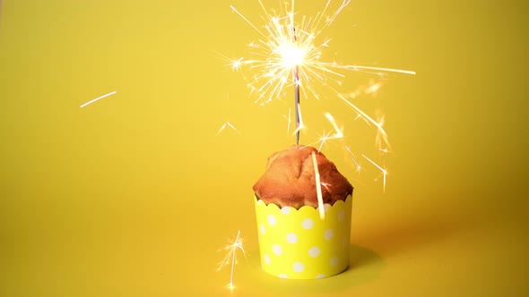 4k Valentines day cupcake or muffin with sparklers on a yellow background