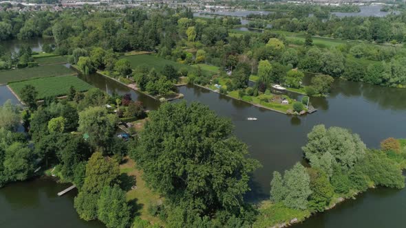 Drone Slomo shot flying towards a Small Boat with Friends sailing, surrounded by Dutch Countryside,