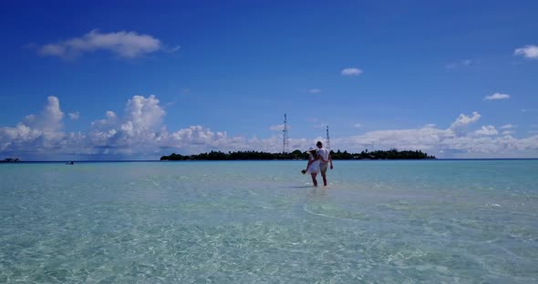 Beautiful lady and man on romantic honeymoon have fun on beach on clean white sand background 