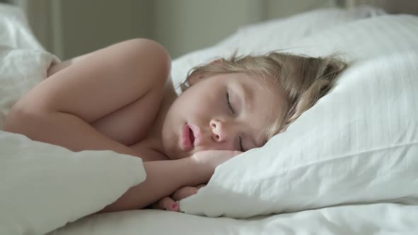 Peaceful Little Girl Sleeping on Bed in Room