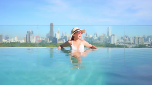 Young asian woman enjoy around outdoor swimming pool for leisure