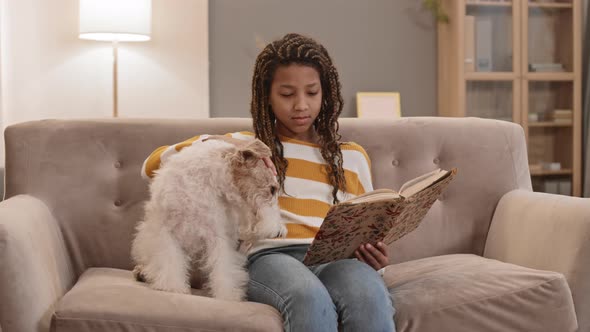 Girl Reading Sitting with Dog