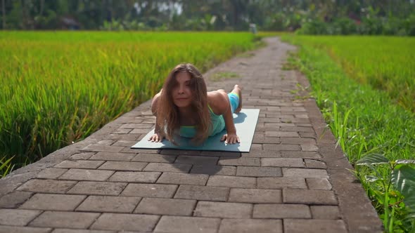 Slowmotion Shot of a Young Woman Practicing Yoga on a Beautiful Rice Field