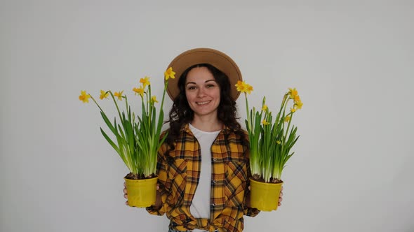 Beautiful Young Woman Florist with Flowers on White Background Smiling at Camera