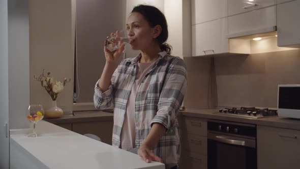 Adult Woman Drinking Glass of Water Enjoying Freshness Smiling Indoors