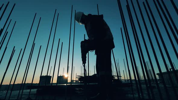 Male Constructor Is Using a Jackhammer To Break Concrete