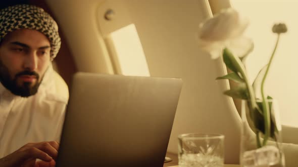 Focused Businessman Using Laptop on Aircraft