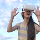 Slow motion 4K of Asian girl having fun with virtual reality glasses while standing over the sky. - VideoHive Item for Sale