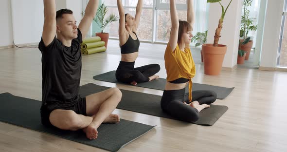 Young Diversity Sporty People Practicing Yoga Lesson with Instructor Lotus Pose