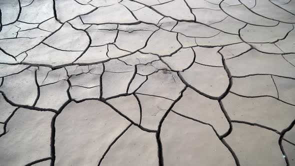 Panning view of cracking mud after a flood in Utah