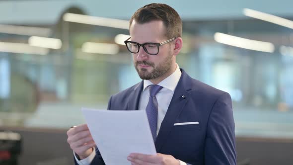 Portrait of Middle Aged Businessman Reading Documents