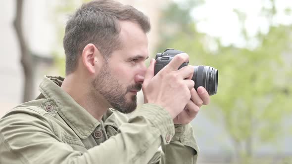 Handsome Man Clicking Pictures Outdoors on Camera