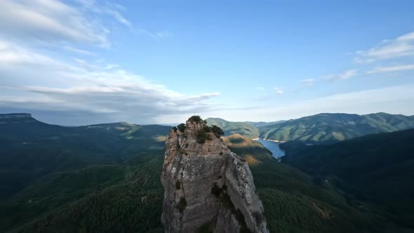 Dynamic Drone Shot Along Rocky Mountain Cliff and Around the Cross