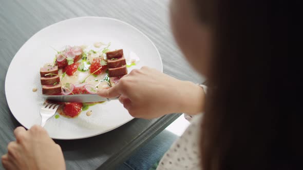 Elegant Woman Eating Tuna Steak with Colorful Salad in High Kitchen Restaurant Haute Cuisine Fine