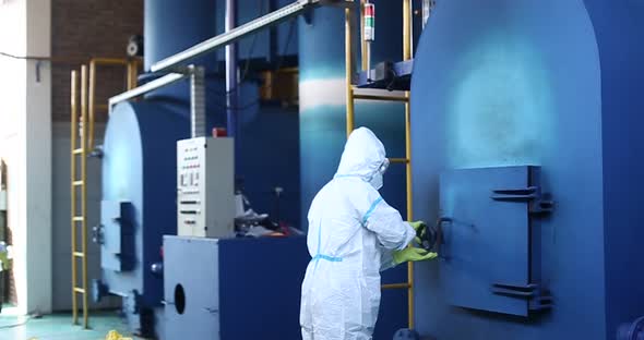 The officer opens the incinerator door to enter the waste or garbage to be burned in the incinerator