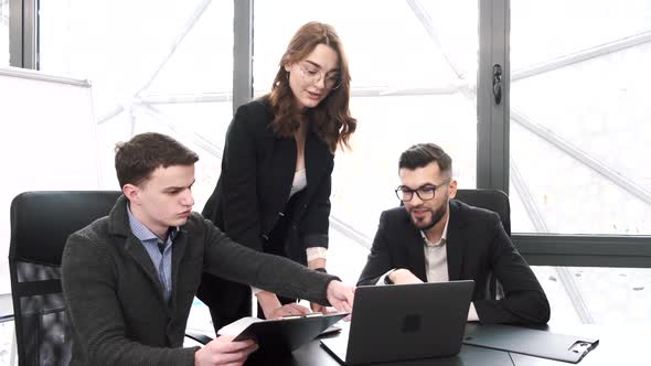 Three Coworkers Working on a Project at Office