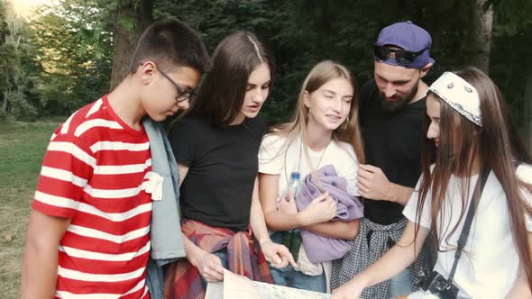 Group of Tourists Searching for Places on Their Map Outdoors