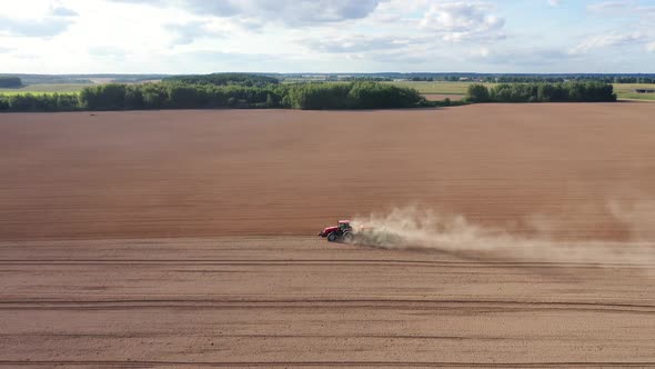 Farm Tractor Plows Soil Before Planting And Plants Crop In Field In Spring Fall