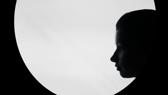 Silhouette of Beautiful Young Woman With Finger on Lips, Keep Silence Gesture