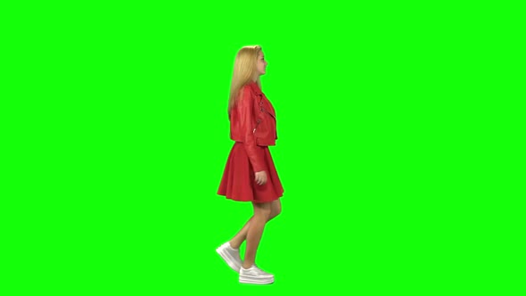 Blonde Girl Is Running To a Meeting with Lovely Smile at Green Screen. Chroma Key. Profile View