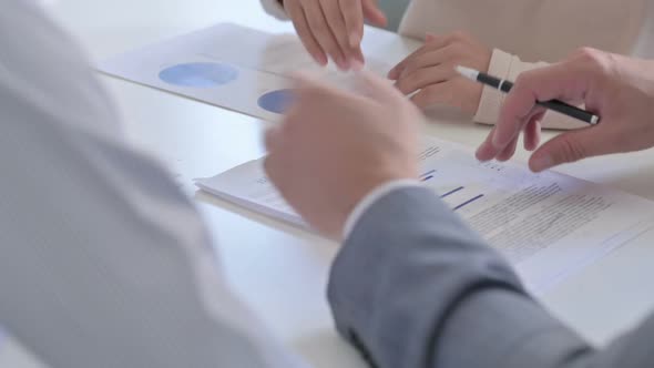 Close up of Hands of Business People Reading Documents, Writing on Paper