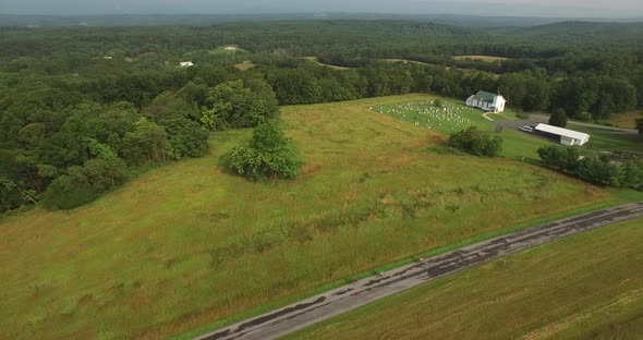 Aerial views of family bicycling along pastoral country roads.