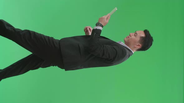 Side View Of Asian Business Man Use Tablet While Walking On Green Screen Chroma Key