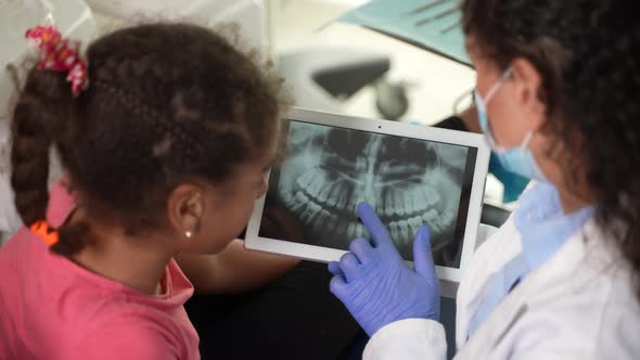 Dentist and Child Patient Looking at Dental Xray