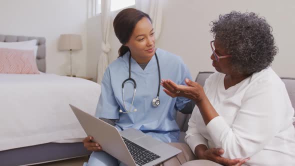 Mixed race woman being visited at home by a nurse. Social distancing and self isolation in quarantin