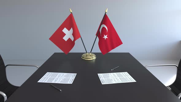 Flags of Switzerland and Turkey and Papers on the Table