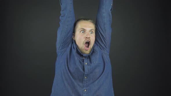 Fashionable Bearded Guy in Blue Denim Shirt Raises Hands