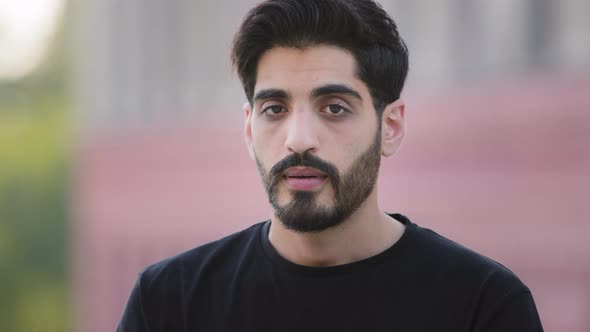 Young Bearded Indian Ethnicity Millennial Man in Black Tshirt Standing Outdoors Making Deep Breath