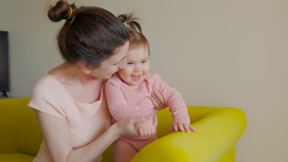 Happy Mother Playing with Baby at Home