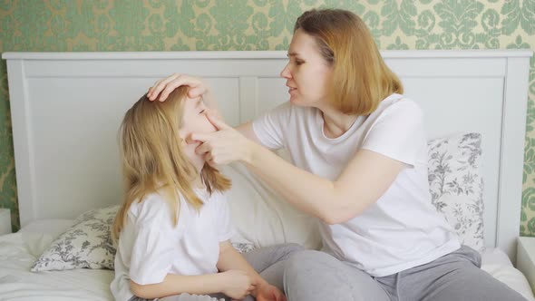Daughter Complains About a Mote or Pain in Eye and Mother Examines Her