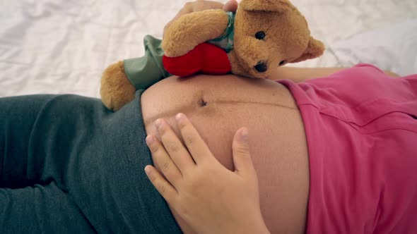 Happy Pregnant Woman Sleeping on Bed in Bedroom