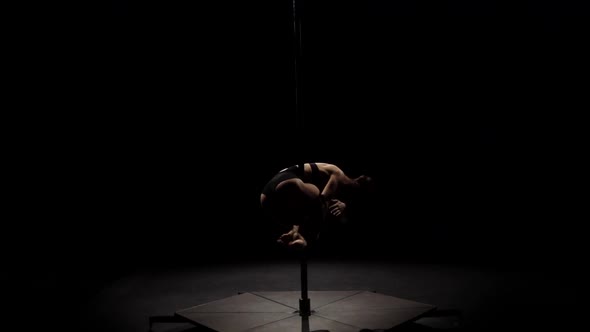 Stripper Doing Pole Dance . Black Background. Slow Motion. Silhouette