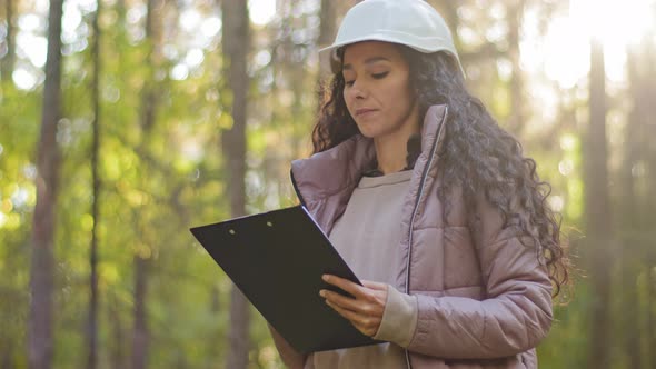 Millennial Female Technician Ecologist Looking Up at Treetops Young Indian Woman in Hardhat with