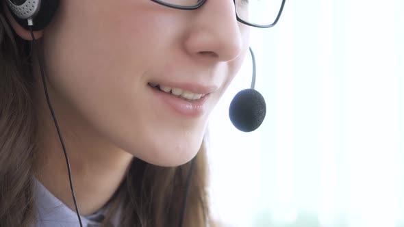 Closeup of the Face of a Young Girl Wearing Headphones Who Communicates Online Explains Teaches