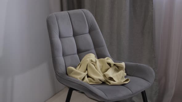 Person Throws Used Clothes on the Chair