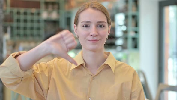 Portrait of Thumbs Down By Disappointed Young Woman 