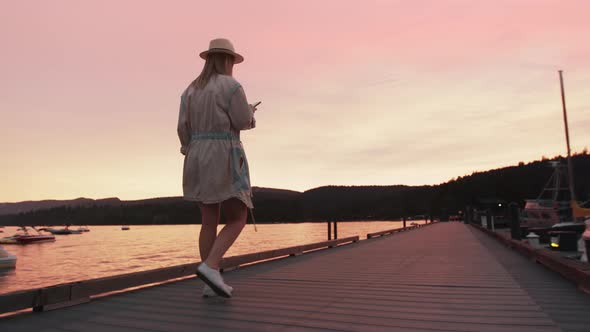 Slow Motion Woman Looking at Phone with Cinematic Pink Sunset Over Lake Tahoe