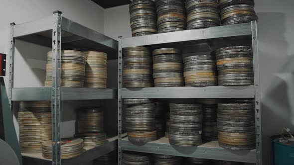 Old round metal boxes, in a dusty vault and leaves. Аrchive with old film tapes. Film storage room