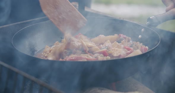 Close Up Fresh Vegetables Are Cooked in a Pan on Open Fire in the Open Air. Slow Motion