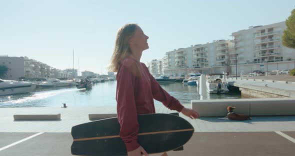 Woman with Skateboard in the Early Morning at Port