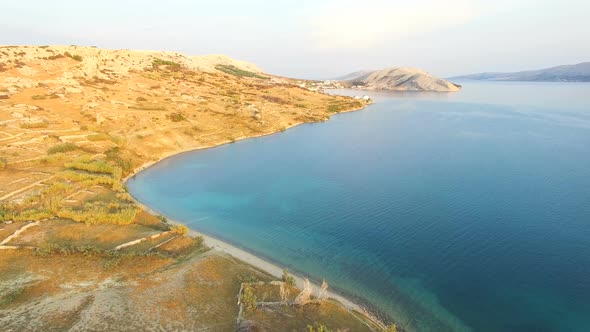 Flying above isolated house in yellow grass of Pag island, Croatia