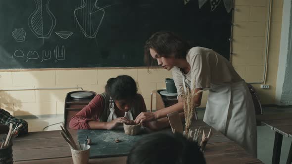 Woman Helping Girl Sculpting Clay