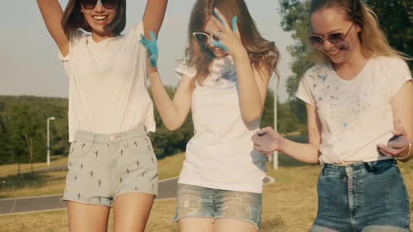 Three happy beautiful women making party at Holi colors festival having fun