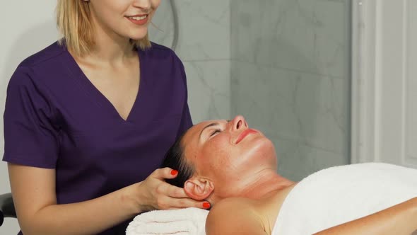 Relaxed Happe Woman Getting Head Massage at Spa Center