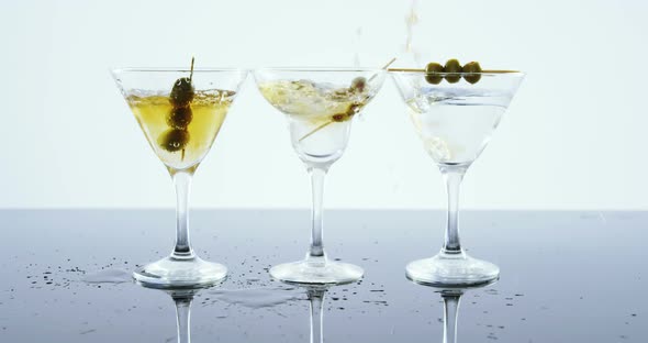 Yellow drink being poured into three glasses of cocktail