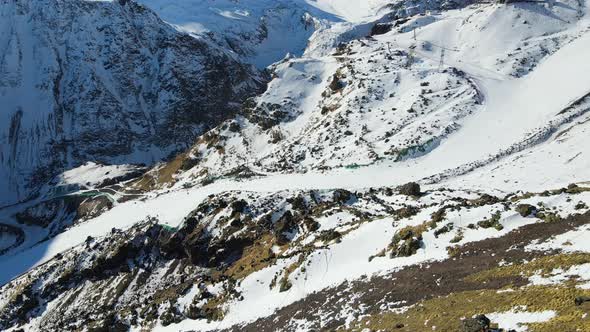 Ski Slope with Downhill Skiers Among the Gray Rocks on the Slopes of Elbrus